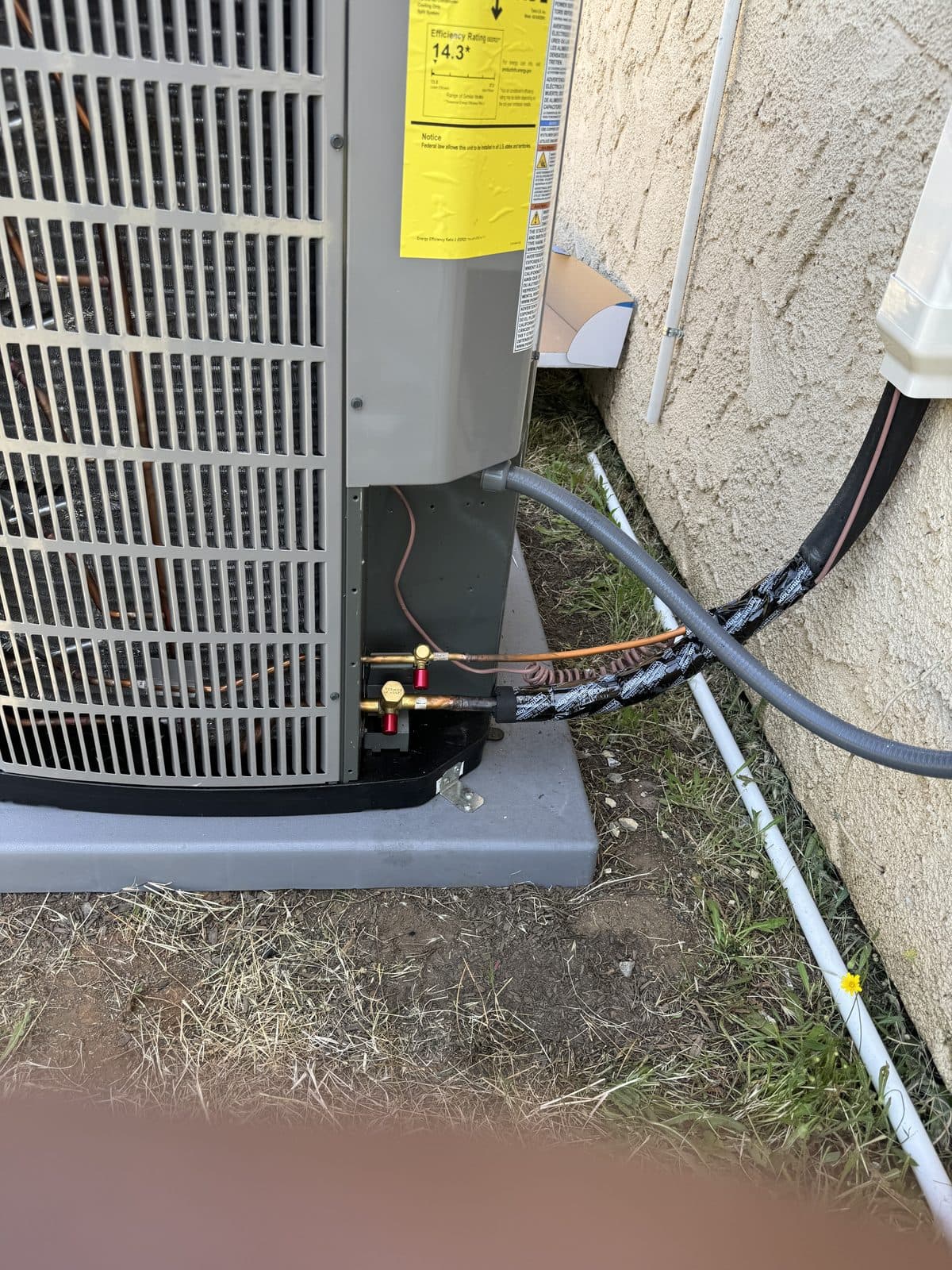 Technician-installed refrigerant line connection at an AC condenser