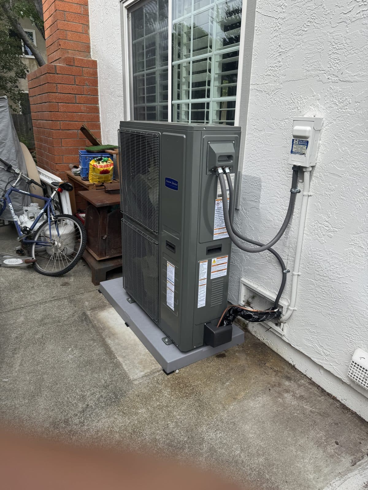 Heat pump condenser installed in a backyard