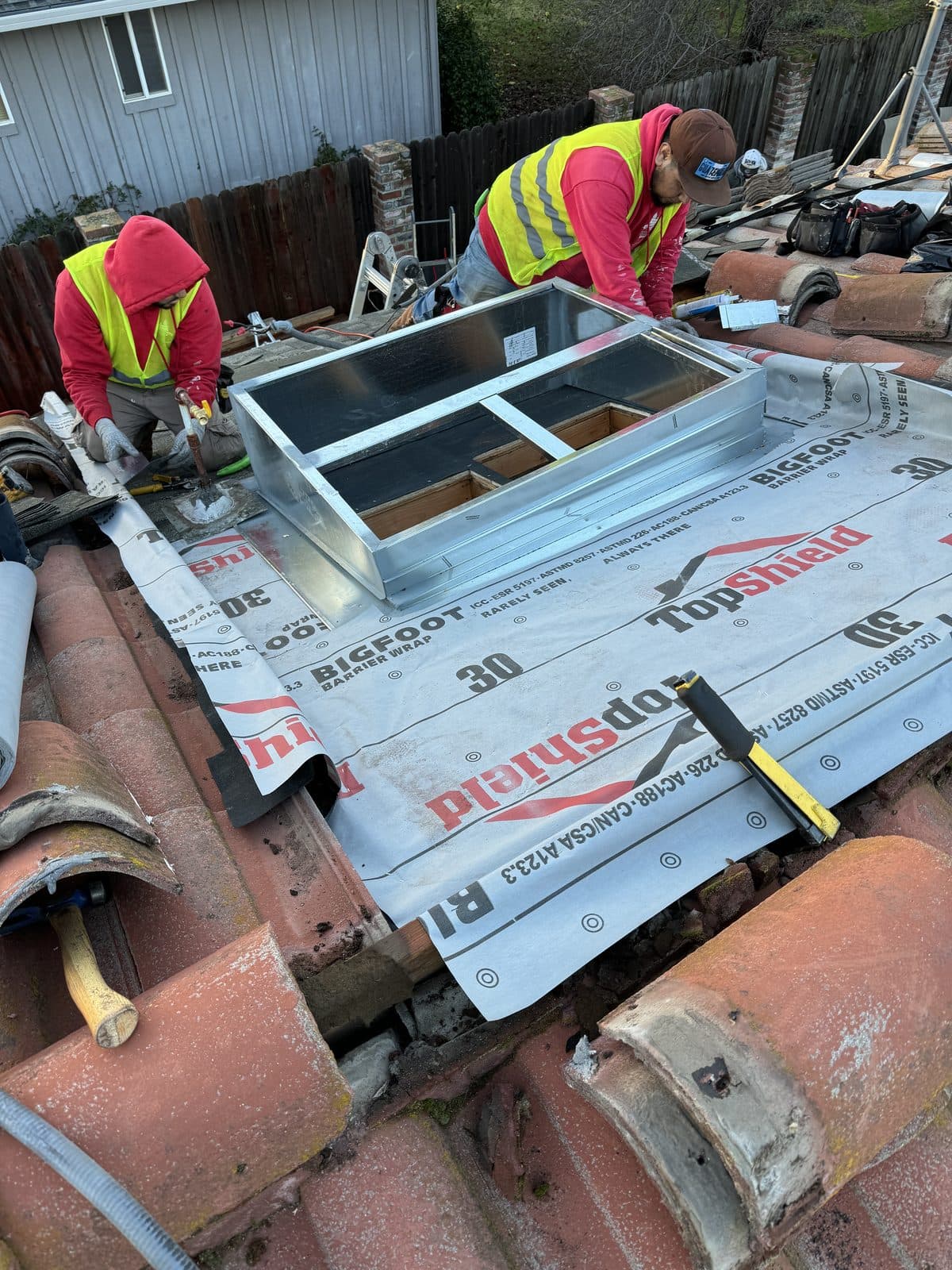 New Day HVAC technicians installing a roof vent
